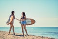 Surfers on beach having fun in summer. Smiling girls with a surf