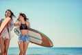 Surfers on beach having fun in summer. Young girls with a surf b Royalty Free Stock Photo