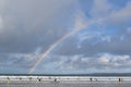 Surfers on the beach in Newquay Cornwall beautiful summer day with a genuine double rainbow over the ocean sea horizon