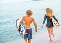 Surfers at the beach- Smiling couple of surfers run on the sea and having fun in summer. Extreme sport and vacation Royalty Free Stock Photo