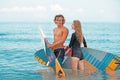 Surfers at the beach- Smiling couple of surfers walking on the beach and having fun in summer. Extreme sport and Royalty Free Stock Photo