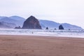 Surfers at Cannon Beach with Haystack Rock in the background Royalty Free Stock Photo