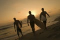 Surfers Carrying Surfboards Out Of Surf At Sunset Royalty Free Stock Photo