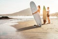 Surfers couple waiting for the high waves on beach - Sporty people with surf boards at sunset - Extreme sport and vacation concept Royalty Free Stock Photo