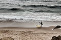 Surfers at Guincho beach under cloudy sky in Portugal