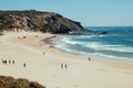 Surfers having fun on sandy beach with ocean waves and wind. Landscape with seaside of Portugal Royalty Free Stock Photo