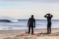 Surfers preparing to enter the ocean in wetsuits to catch large waves. Winter surfing - Long Beach NY Royalty Free Stock Photo