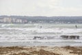 Surfers ride big waves in the bay