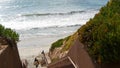 Surfers on stairs. Man woman going surfing, coastal stairway, beach access. People in California USA