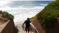 Surfers on stairs. Man woman going surfing, coastal stairway, beach access. People in California USA