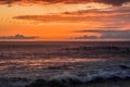 Surfers in the sunset awaiting the final ride