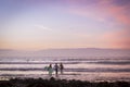 Surfers surf on the waves, bright sunset on the coast, Tenerife, Canary Islands, Spain