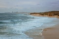 Surfers surf on the waves at Palmahim beach in Israel at sunset