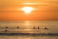 Surfers waiting in the water for the next wave. Sunset at Unstad beach Royalty Free Stock Photo