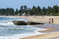 Surfers walk past Seven Star Rock at Arugam Bay on the east coast of Sri Lanka.