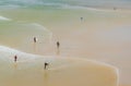Surfers walking along a sandy beach Royalty Free Stock Photo