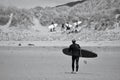 Surfers walking back from the water`s edge at Llangennith Beach on the Gower Peninsula