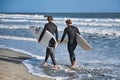 surfers walking with board on beach Charleston
