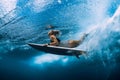 Surfgirl with surfboard dive underwater with under ocean wave
