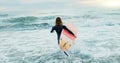 Surfing, beach and woman in water for surfboard for sports, fitness and freedom by ocean. Nature, travel and back of