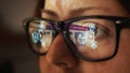 Surfing the Internet and gears in the reflection of glasses on a female face. Cg