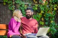 Surfing internet together. Couple with laptop sit bench in park nature background. Family surfing internet for Royalty Free Stock Photo