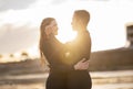 Surfing Soulmates. Romantic Young Couple Wearing Wetsuits Embracing On Beach At Sunset Royalty Free Stock Photo