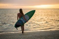 Surfing surfer girl looking at ocean beach sunset. Silhouette of female bikini woman looking at water with standing with Royalty Free Stock Photo