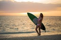 Surfing surfer girl looking at ocean beach sunset. Silhouette of female bikini woman looking at water with standing with Royalty Free Stock Photo