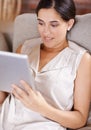 Surfing with the touch of her finger. a young woman lying on a sofa using a digital tablet. Royalty Free Stock Photo