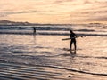 Surfing under a winter sunset