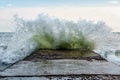 Surfing wave breaks with splashes against spurdike during the storm on Black Sea coast Royalty Free Stock Photo