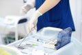 Surgeon or assistant takes sterile instrument during operation in clinic. Steel medical instruments are ready to be used. Modern Royalty Free Stock Photo