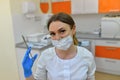 The surgeon dentist in mask holding syringe for injecting.