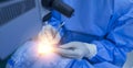 Surgeon or doctor in blue uniform did microsurgery inside operating room with light effect.Eye surgery or brain surgery in theater