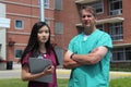 Surgeon, Doctor, Physician, Clinician and Asian Nurse Wearing Scrubs Stand in Front of Hospital