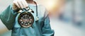 Surgeon doctor woman holding alarm clock showing 7 am or pm Royalty Free Stock Photo