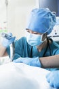 Surgeon looking down and holding surgical equipment in the operating room, close-up