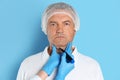 Surgeon with marker preparing for operation against blue background. Double chin removal Royalty Free Stock Photo