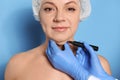 Surgeon with marker preparing woman for operation against background. Double chin removal Royalty Free Stock Photo