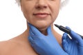 Surgeon with marker preparing woman for operation against white background. Double chin removal Royalty Free Stock Photo