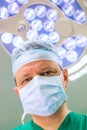 Surgeon in operation room with lamp on background. Royalty Free Stock Photo