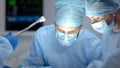 Surgeon performing operation, assistant hand holding medical tools, medicare