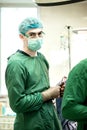 Surgeon performing surgery on breasts in hospital operating room. Surgeon in mask wearing surgical loupes during medical procedure Royalty Free Stock Photo