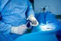 Surgeon performs endoscopic microdiscectomy of herniated intervertebral disc.