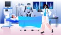 surgeon with robotic assistant making operation to patient lying on bed emergency medical treatment concept