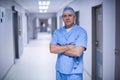 Surgeon standing with arms crossed in hospital corridor Royalty Free Stock Photo