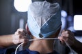 Surgeon tying surgical cap in preparation, back view Royalty Free Stock Photo