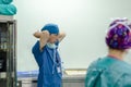 Surgeon tying surgical cap in preparation,