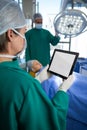 Surgeon using digital tablet while operating patient Royalty Free Stock Photo